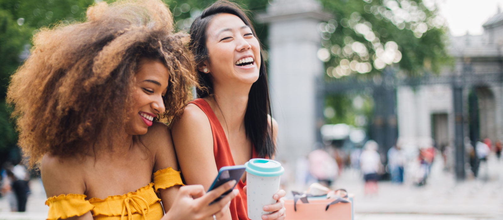 Happy girls using phone outdoors